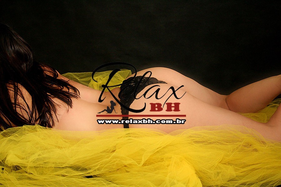 Reclining female model on yellow fabric wearing black lace lingerie, watermark 'Relax BH' across the center.